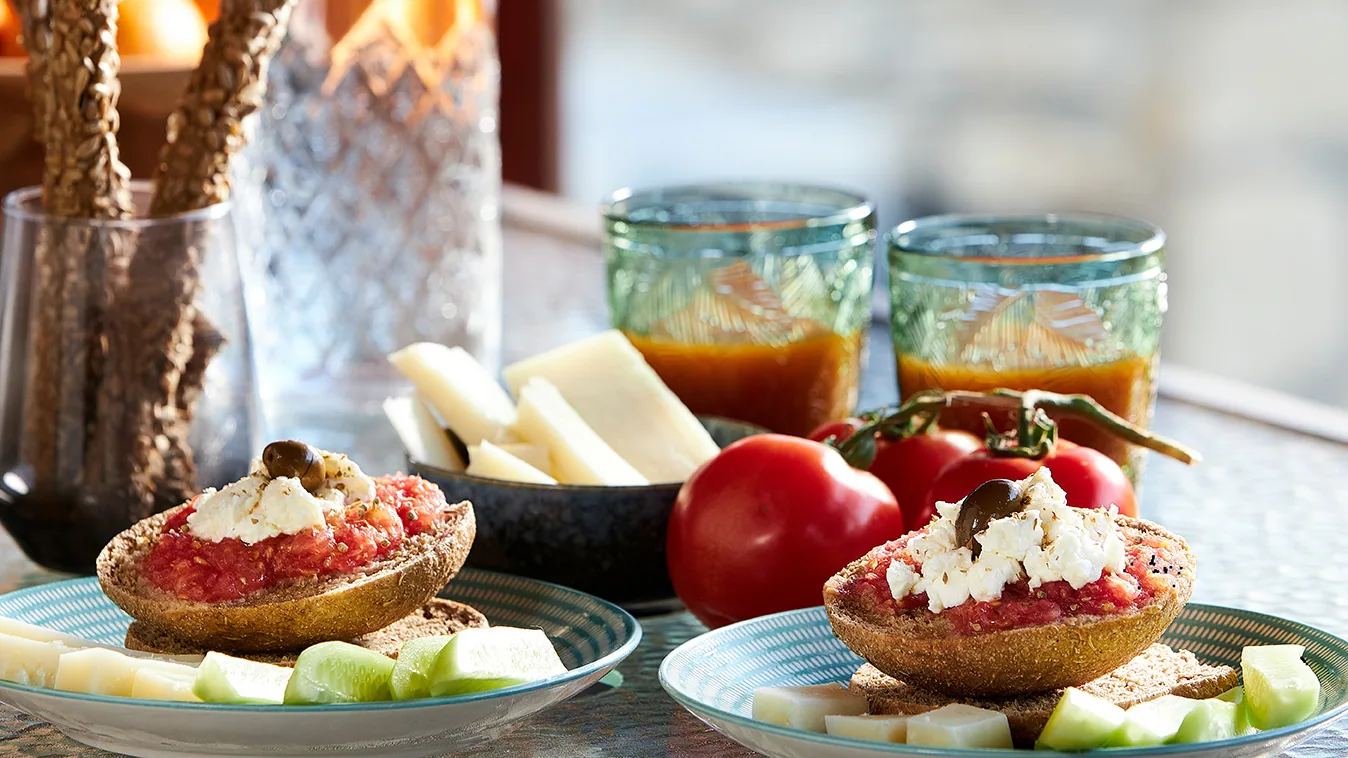 Local Cretan gastronomy with dakos, tomatoes, cheese, cucumber and drinks